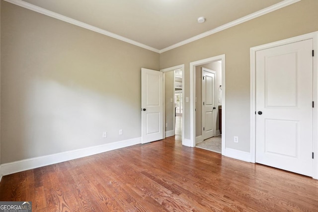 unfurnished bedroom with hardwood / wood-style flooring and ornamental molding