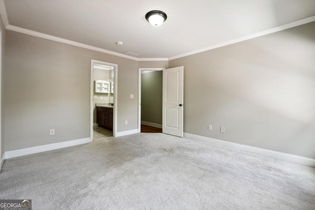 unfurnished bedroom with connected bathroom, crown molding, and light carpet