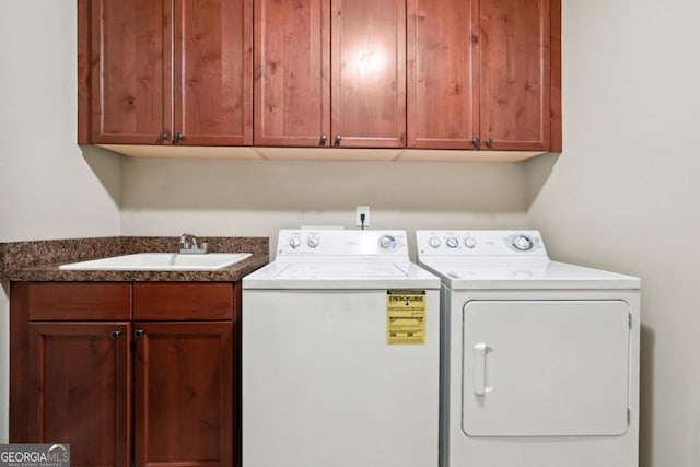 laundry area featuring cabinets, separate washer and dryer, and sink