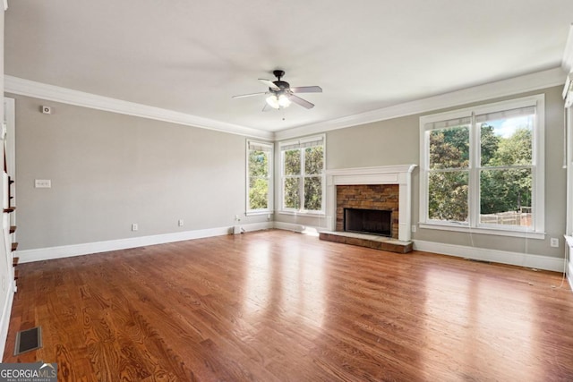 unfurnished living room with a stone fireplace, ceiling fan, hardwood / wood-style floors, and ornamental molding