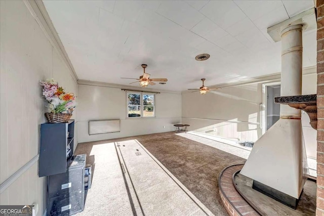 living room featuring carpet floors, decorative columns, ceiling fan, and crown molding