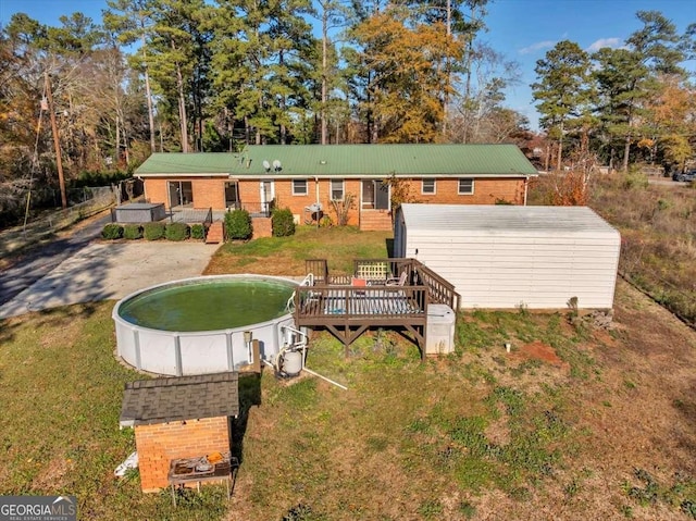 rear view of house with a lawn and a wooden deck