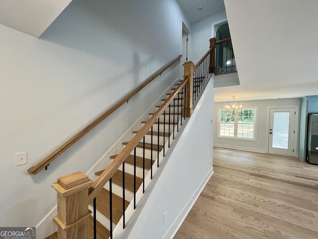 stairs featuring a chandelier and wood-type flooring