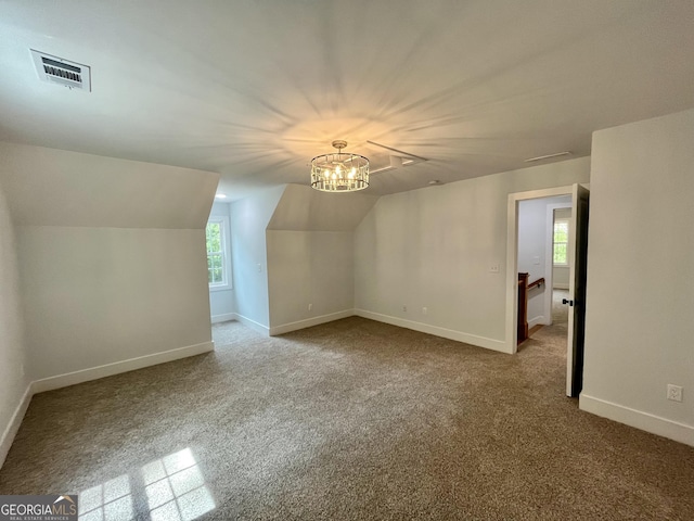 bonus room featuring carpet flooring, vaulted ceiling, and an inviting chandelier