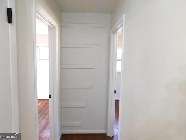 corridor featuring dark wood finished floors