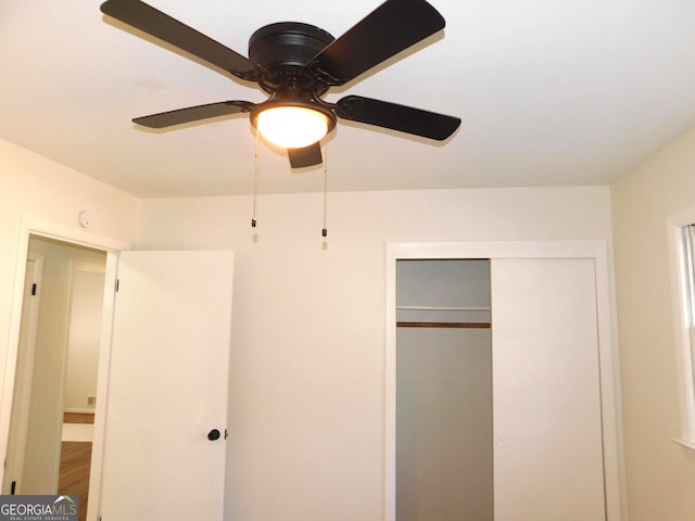 unfurnished bedroom featuring a ceiling fan, a closet, and wood finished floors