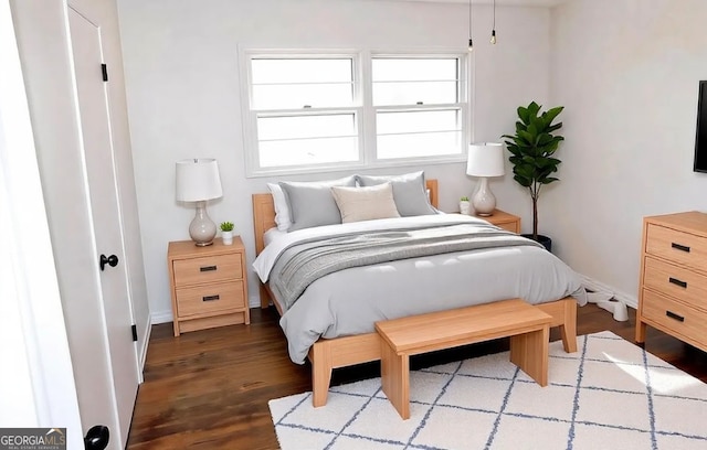 bedroom with wood finished floors and baseboards