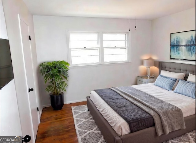 bedroom with wood finished floors and baseboards