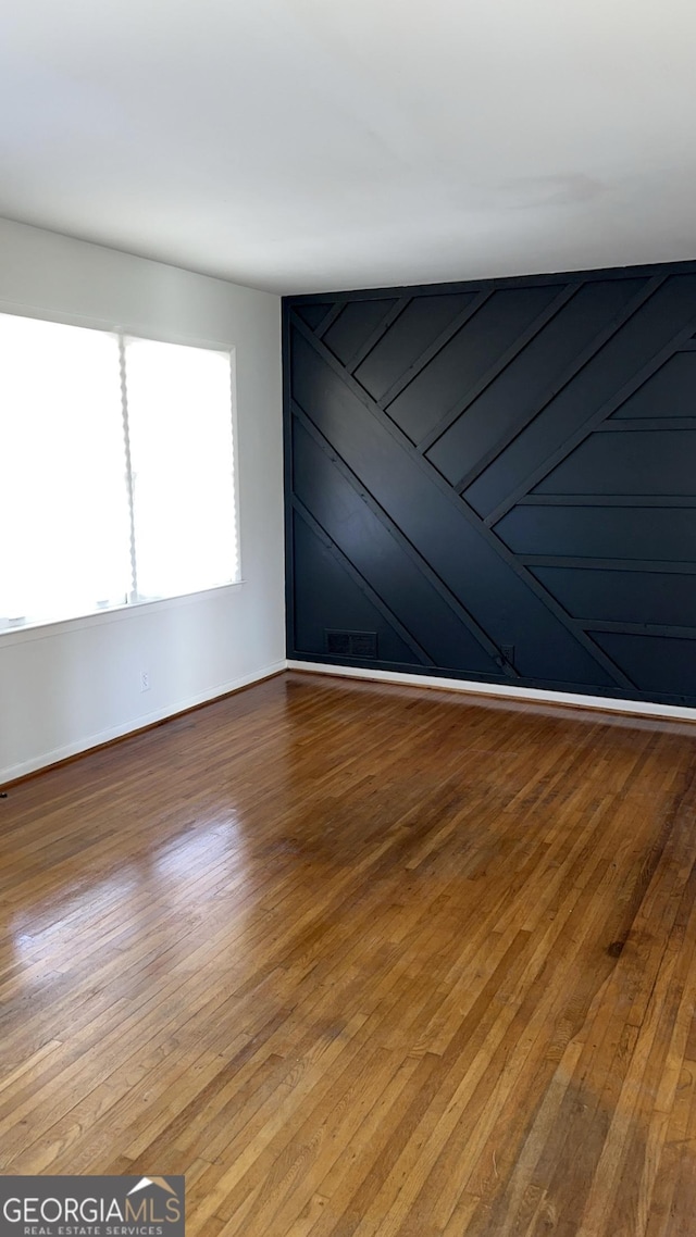 unfurnished room featuring hardwood / wood-style flooring