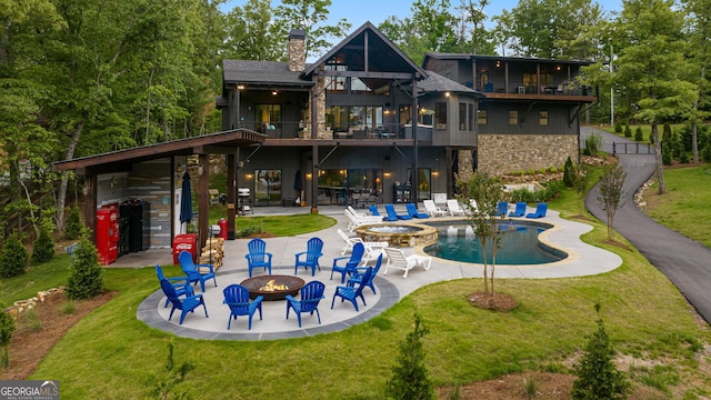 back of property featuring a fire pit, a patio area, and a lawn