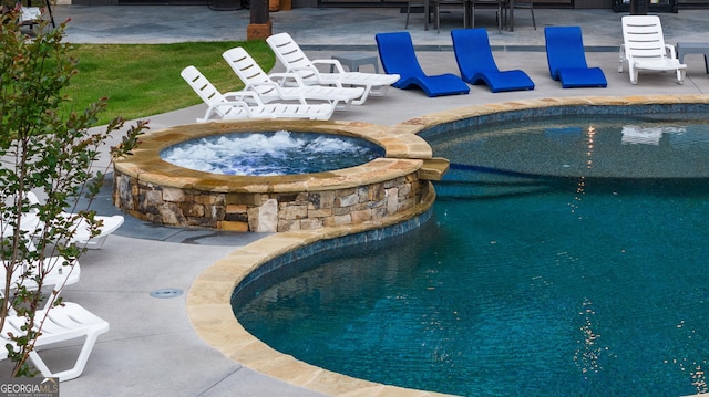 view of swimming pool with an in ground hot tub and a patio