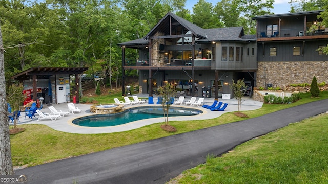 view of pool with an in ground hot tub, a patio area, and a lawn