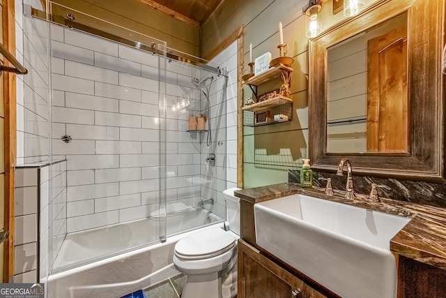 full bathroom with vanity, bath / shower combo with glass door, and toilet