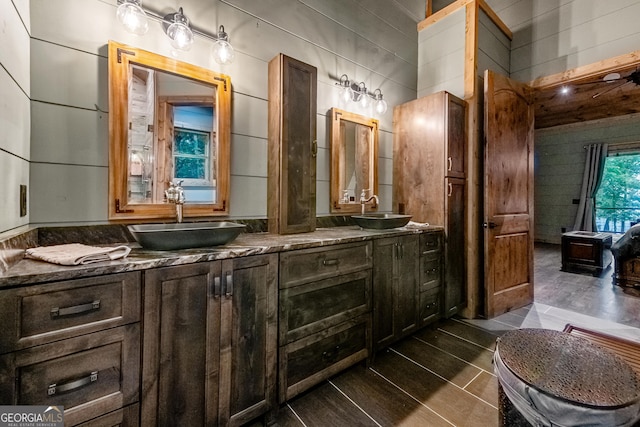 bathroom with vanity and wooden walls