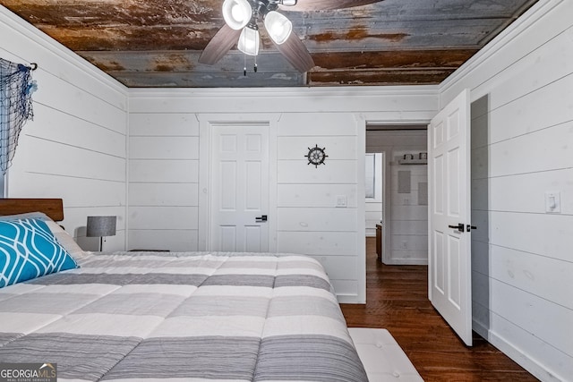 bedroom featuring ceiling fan, dark hardwood / wood-style flooring, wooden ceiling, and wooden walls