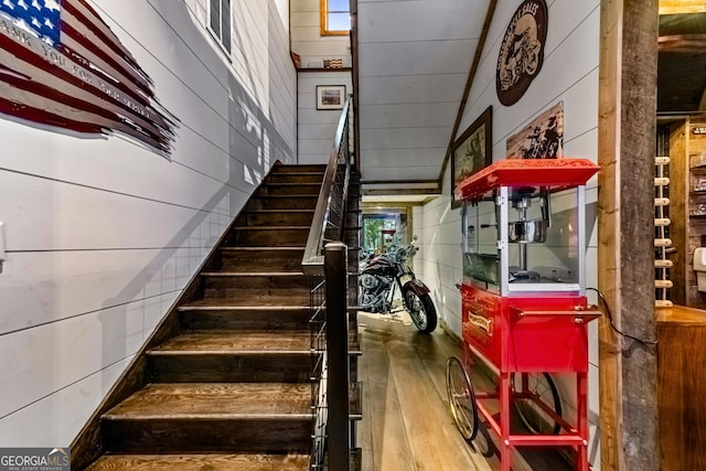 stairway with wood-type flooring and wooden walls