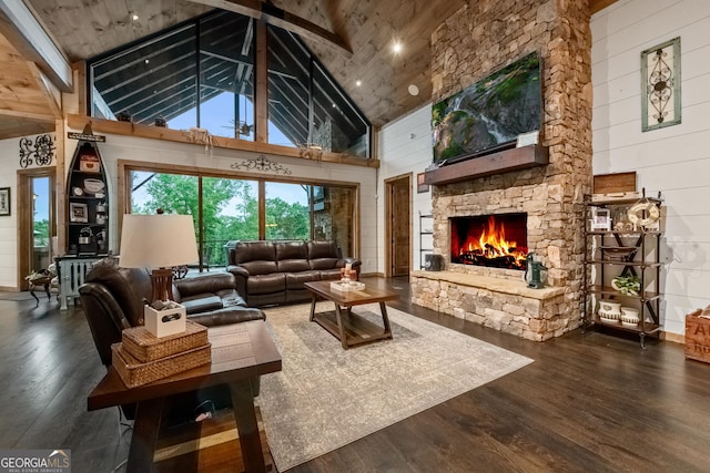 living room featuring wood walls, wooden ceiling, dark wood-type flooring, high vaulted ceiling, and a stone fireplace