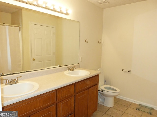 bathroom featuring vanity, toilet, and tile patterned flooring