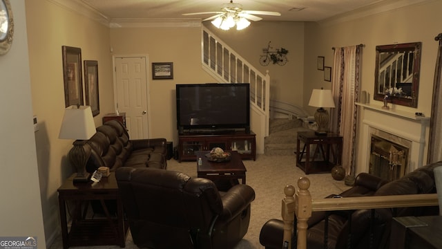 living room with carpet flooring, crown molding, a fireplace, and ceiling fan