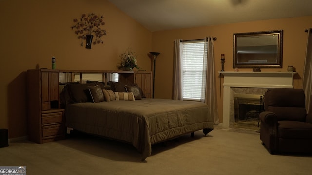 carpeted bedroom with a fireplace and vaulted ceiling