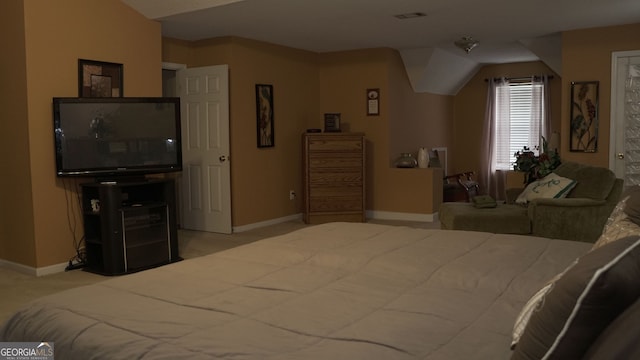 bedroom with light colored carpet and vaulted ceiling