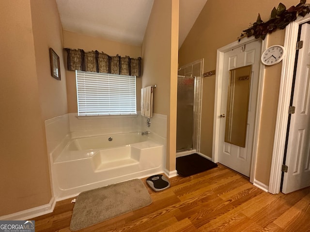 bathroom featuring vaulted ceiling, hardwood / wood-style flooring, and separate shower and tub