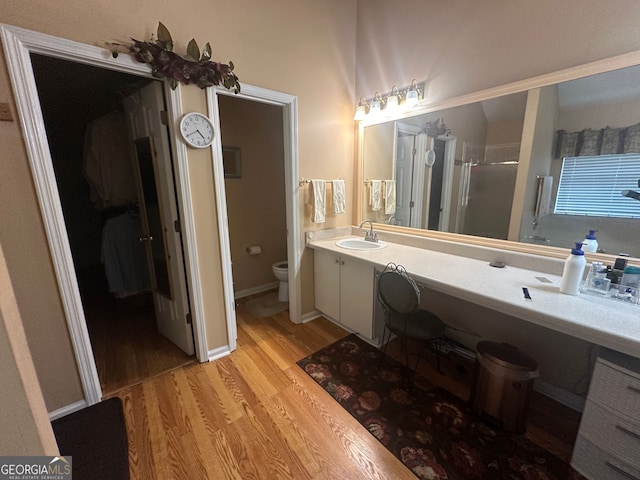 bathroom with vanity, wood-type flooring, an enclosed shower, and toilet