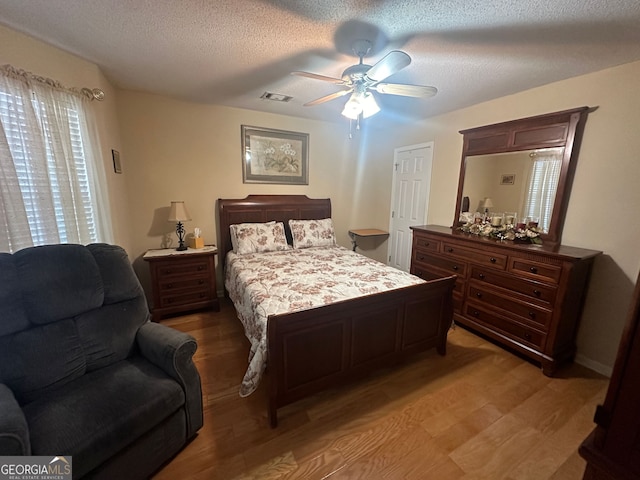 bedroom featuring a textured ceiling, hardwood / wood-style flooring, and ceiling fan