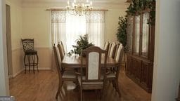 dining space featuring a chandelier, hardwood / wood-style floors, and ornamental molding