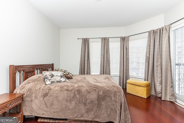 bedroom with dark wood-type flooring and multiple windows