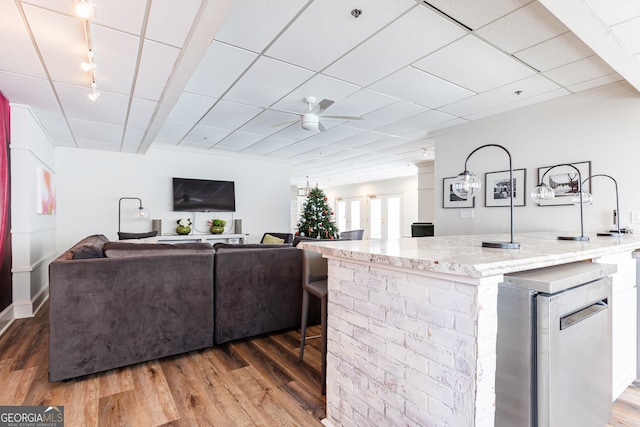 living room with ceiling fan and dark wood-type flooring