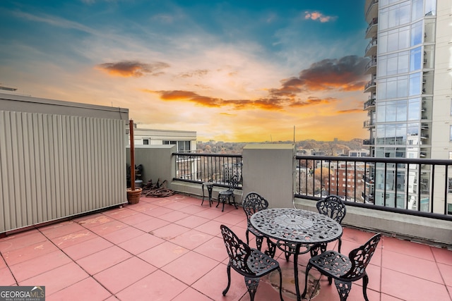 patio terrace at dusk featuring a balcony