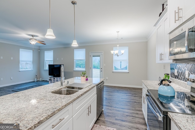 kitchen with light stone countertops, white cabinetry, sink, hanging light fixtures, and appliances with stainless steel finishes