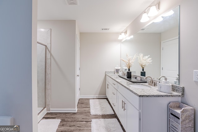 bathroom with a tile shower, vanity, and hardwood / wood-style flooring