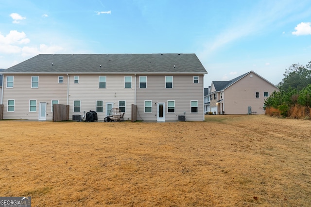 back of house with central AC and a yard