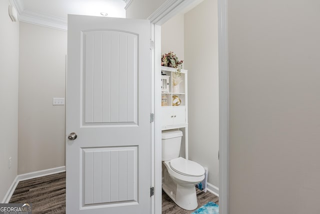 bathroom with hardwood / wood-style flooring, toilet, and ornamental molding