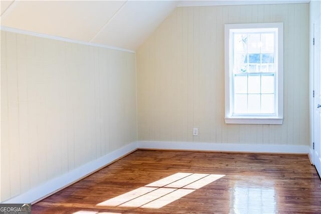 bonus room with lofted ceiling, a healthy amount of sunlight, and dark hardwood / wood-style floors