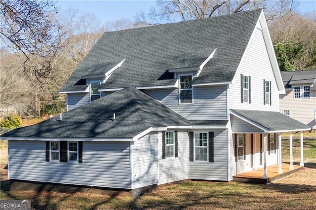 rear view of property featuring covered porch and a yard