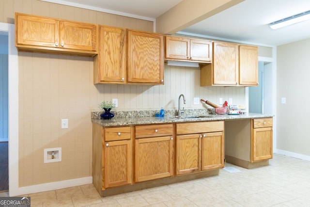 kitchen featuring light stone countertops and sink