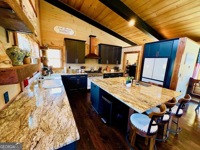 kitchen with a center island, custom range hood, sink, and stainless steel range