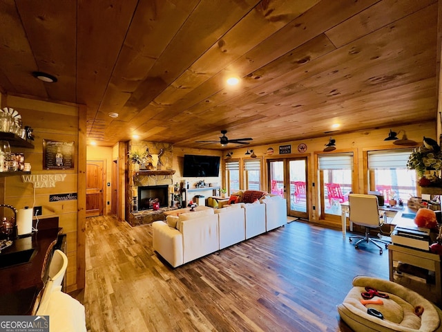 living room featuring ceiling fan, a fireplace, wooden ceiling, and wood-type flooring