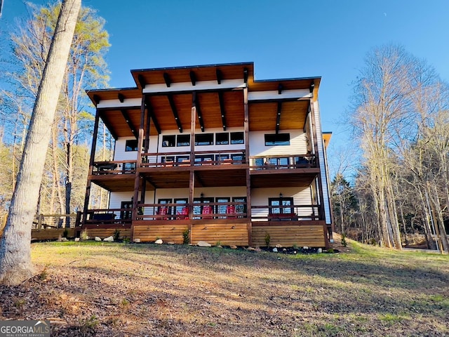 rear view of property with a yard and a deck