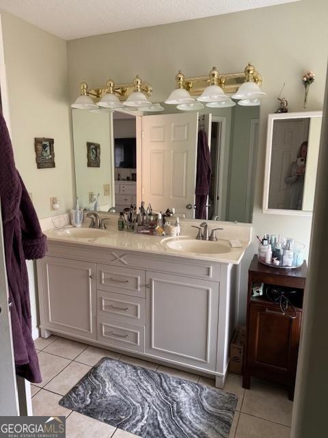 bathroom with tile patterned floors, vanity, and a textured ceiling