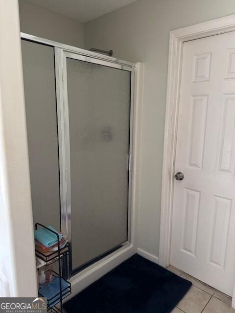 bathroom with tile patterned floors and a shower with door