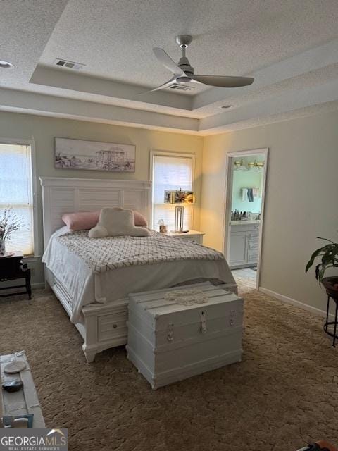 carpeted bedroom featuring a textured ceiling, a raised ceiling, and ceiling fan