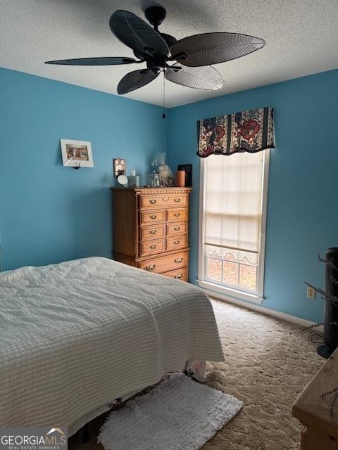 carpeted bedroom with a textured ceiling and ceiling fan