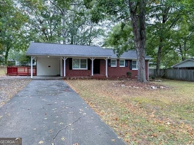 single story home with a front lawn and a carport