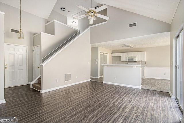 unfurnished living room with ceiling fan, dark hardwood / wood-style flooring, and high vaulted ceiling