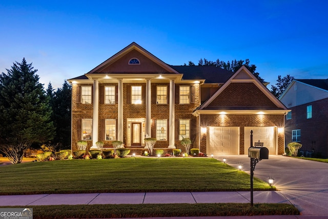 greek revival inspired property with a lawn and a garage