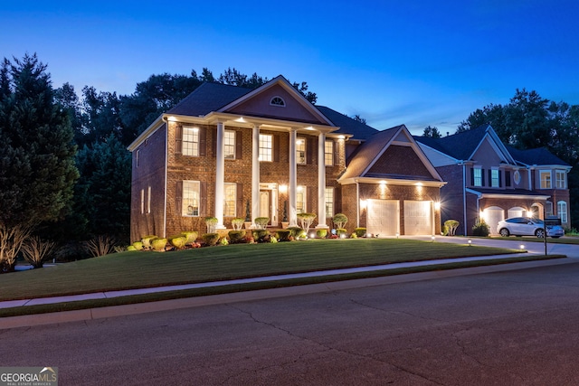 greek revival house with a yard and a garage